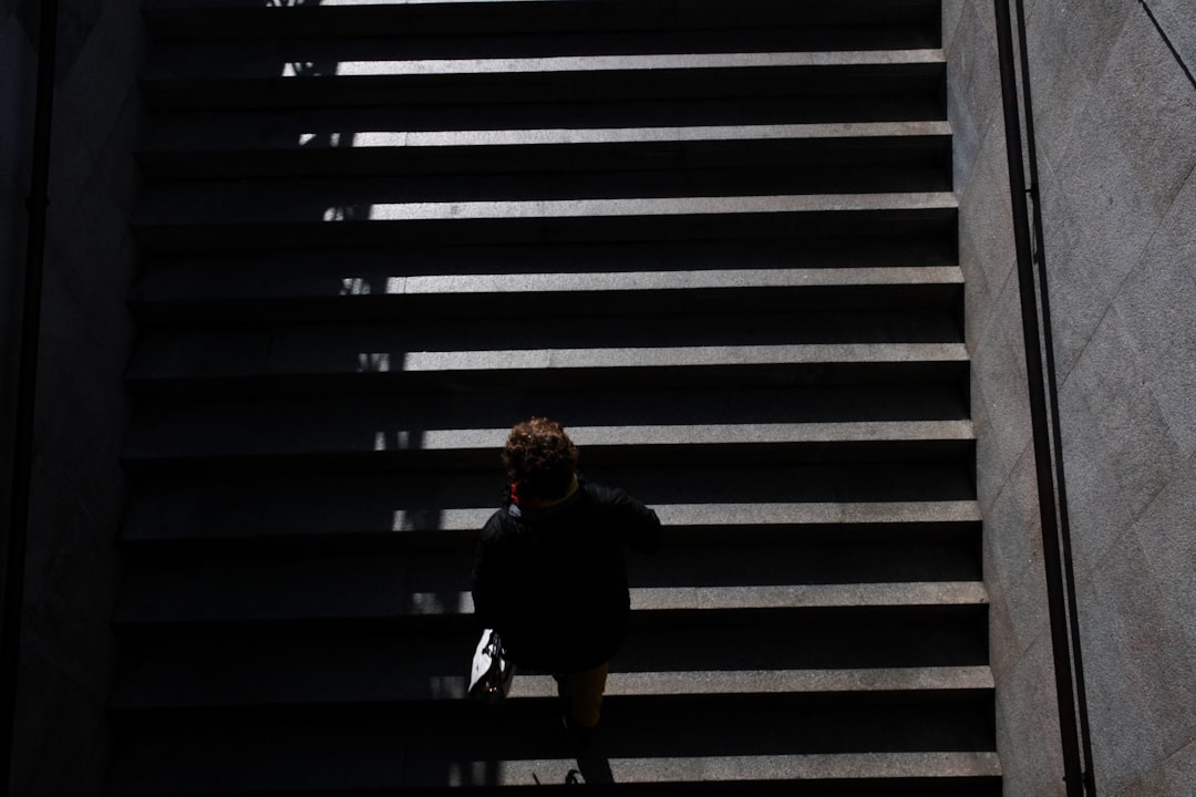 woman in black jacket sitting on stairs