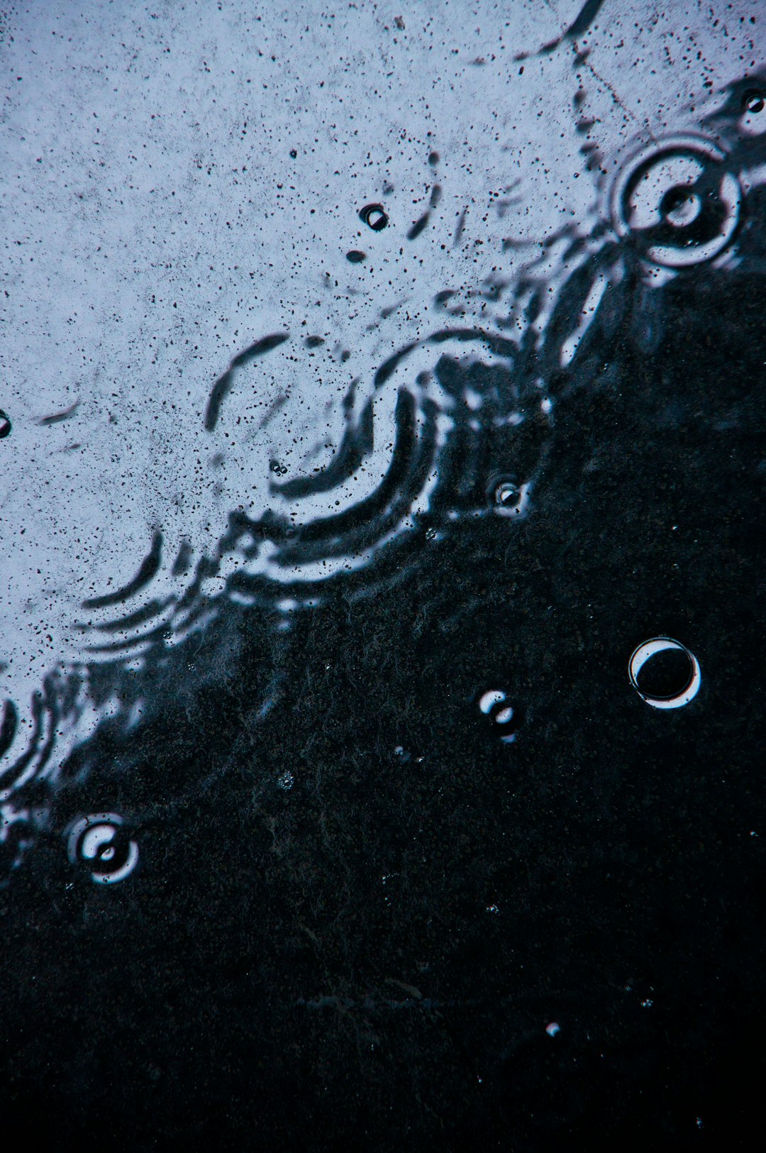 a close up of water droplets on a black surface