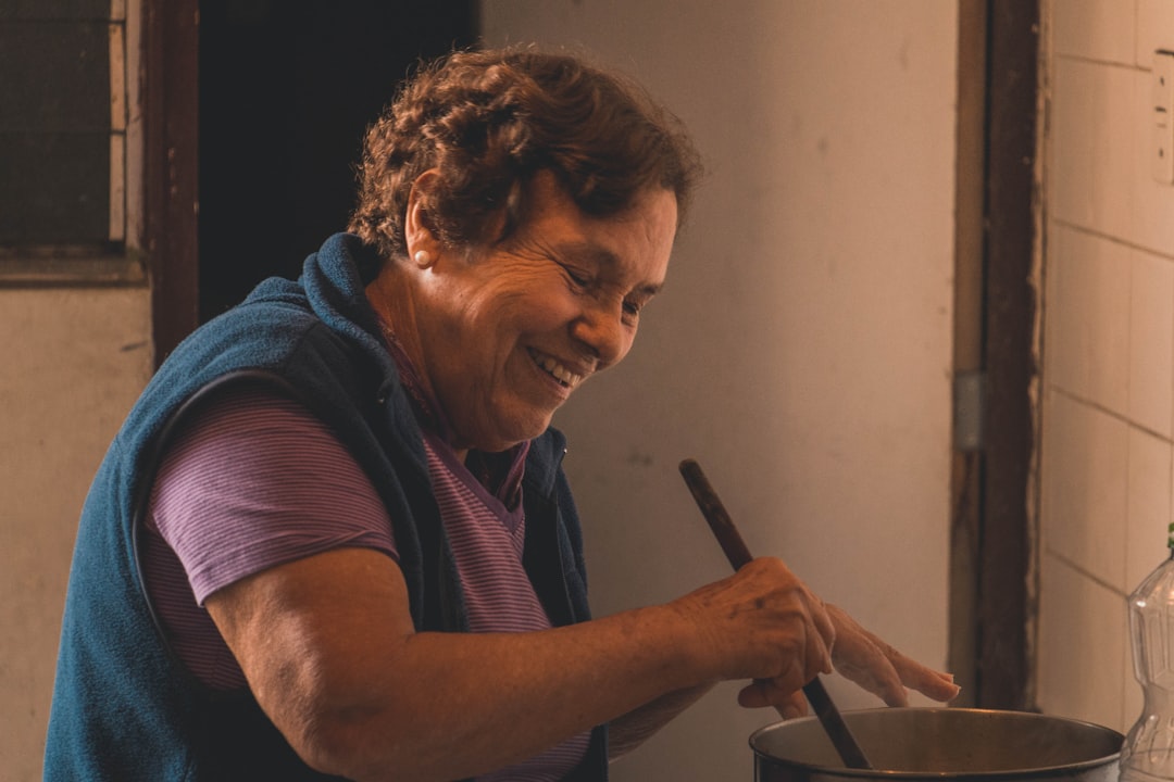 smiling woman cooking inside white room