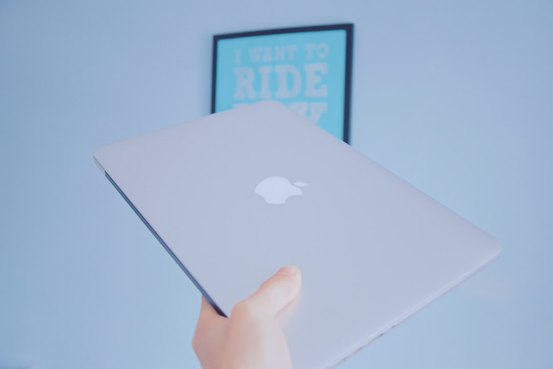 person holding white apple macbook