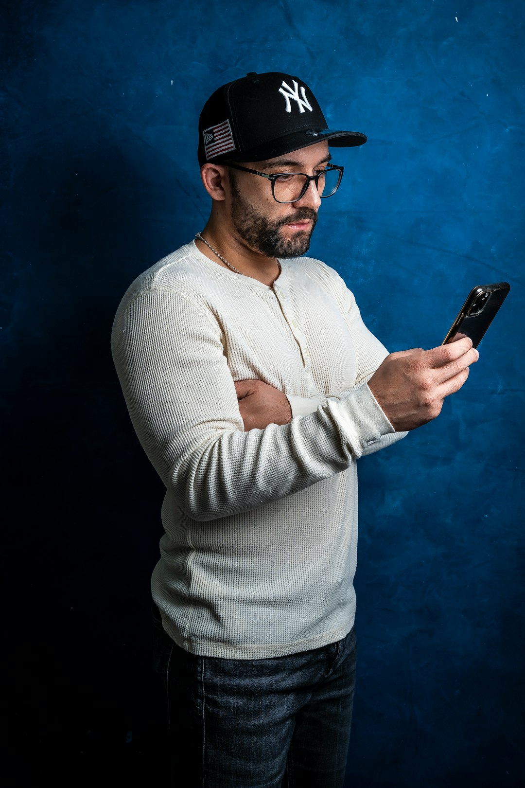 a man in a baseball cap looking at his cell phone