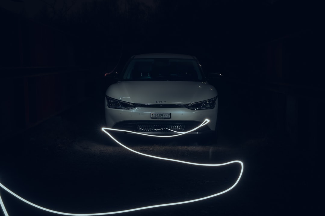 a car is parked in the dark with its headlights turned on