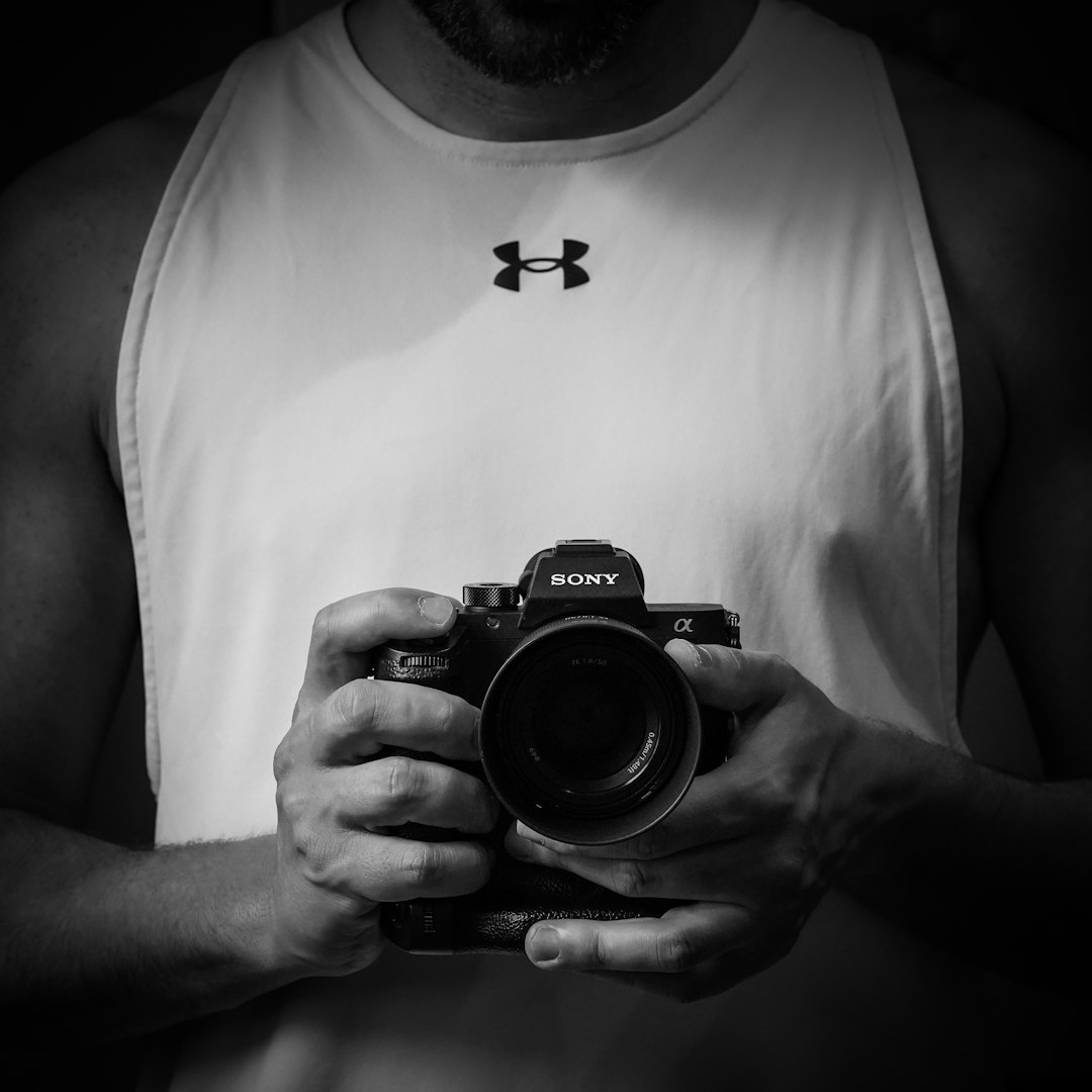 a black and white photo of a man holding a camera