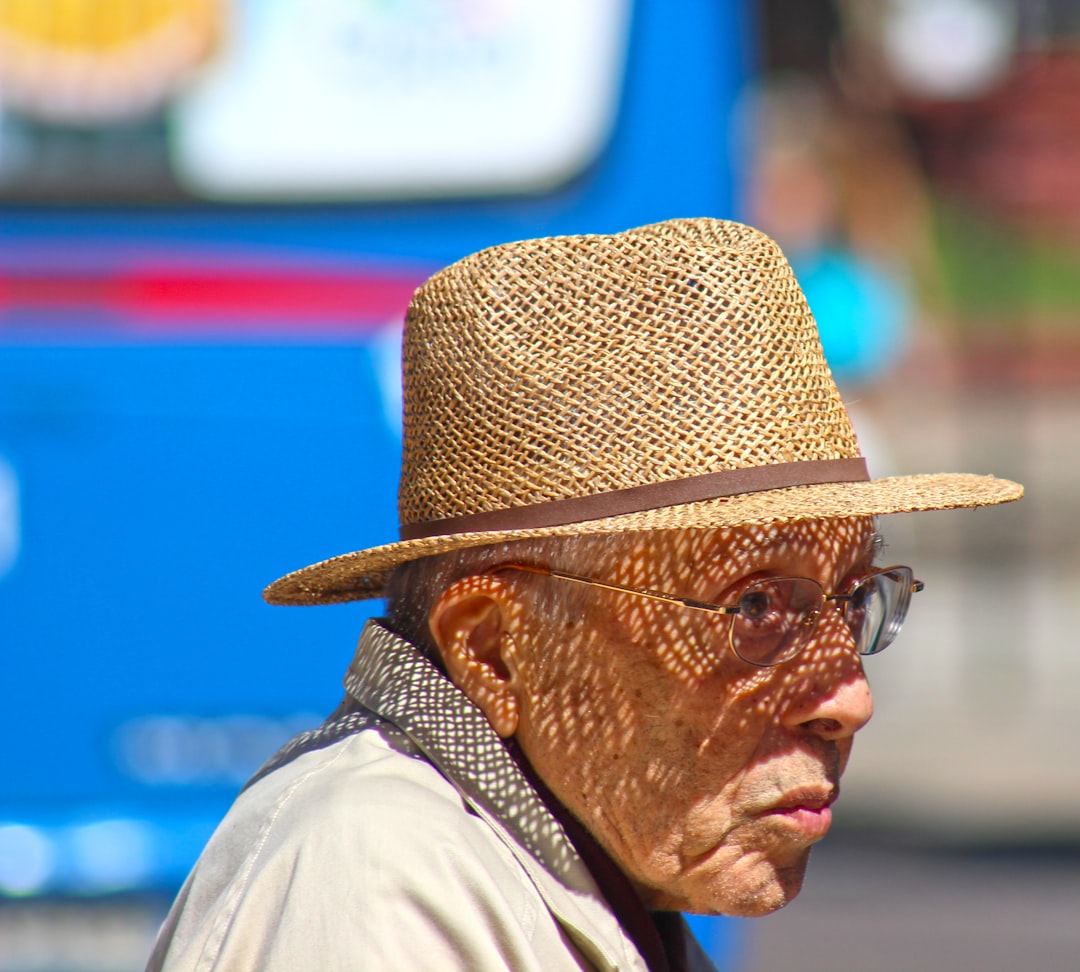An old man wearing a straw hat and glasses