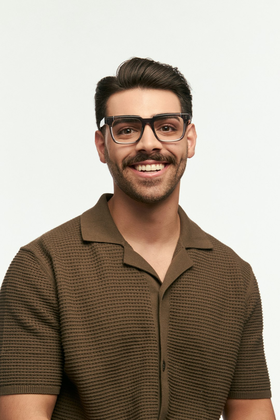 Smiling man with glasses poses for a portrait.