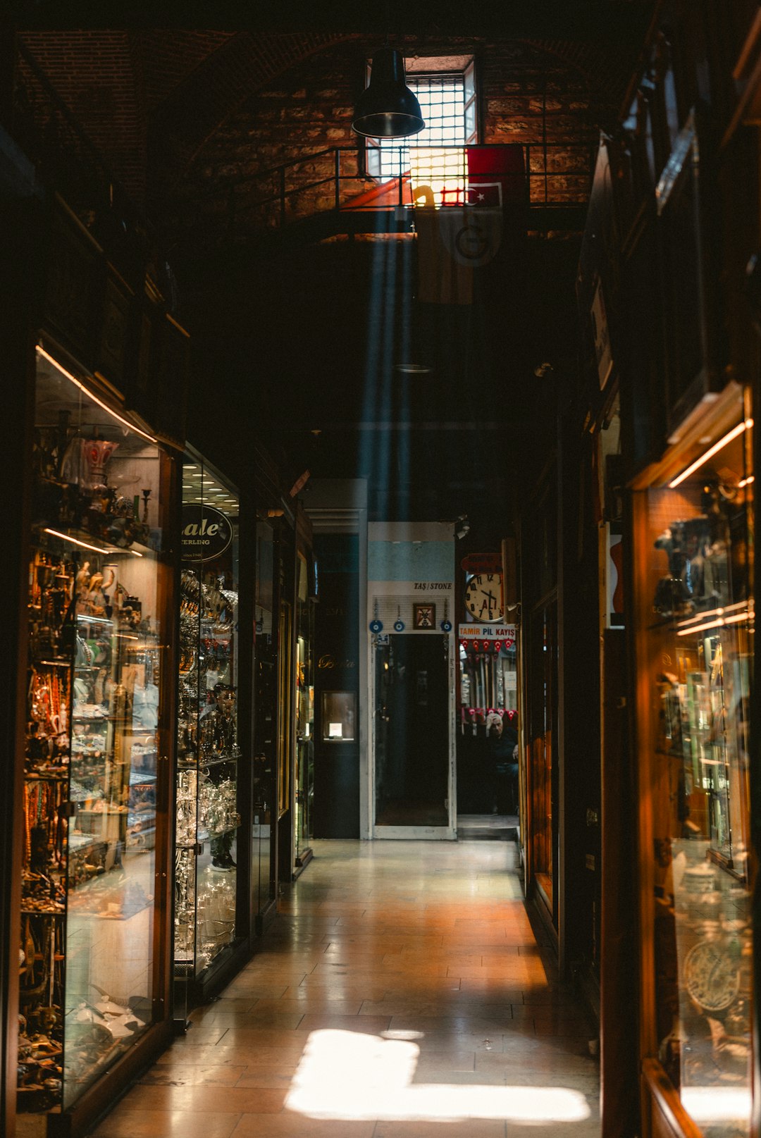 Sunlight streams through a museum hallway with display cases.