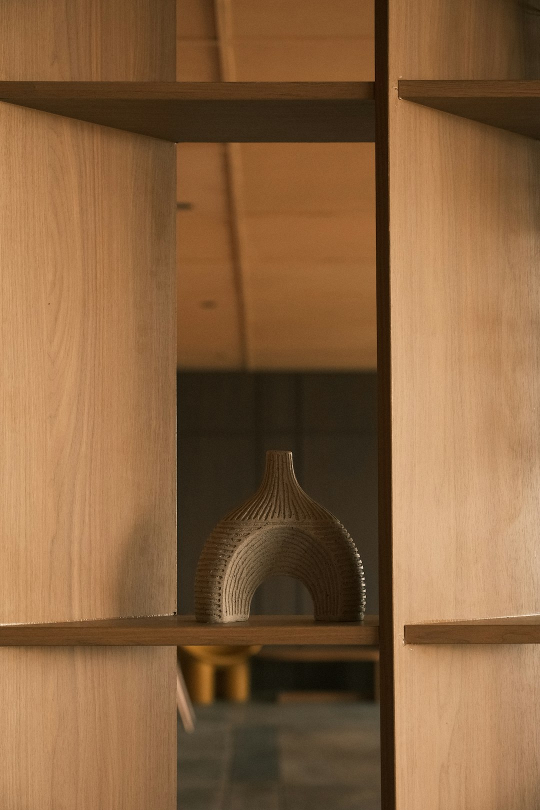 A decorative vase on a wooden shelf