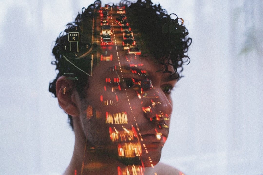 Double exposure of man's face and traffic lights