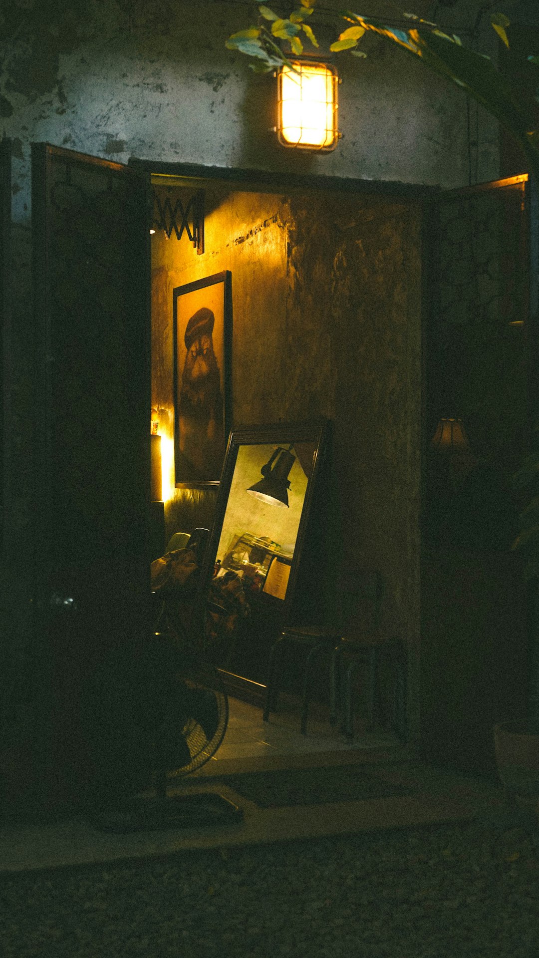 An open doorway with artwork illuminated by a lamp