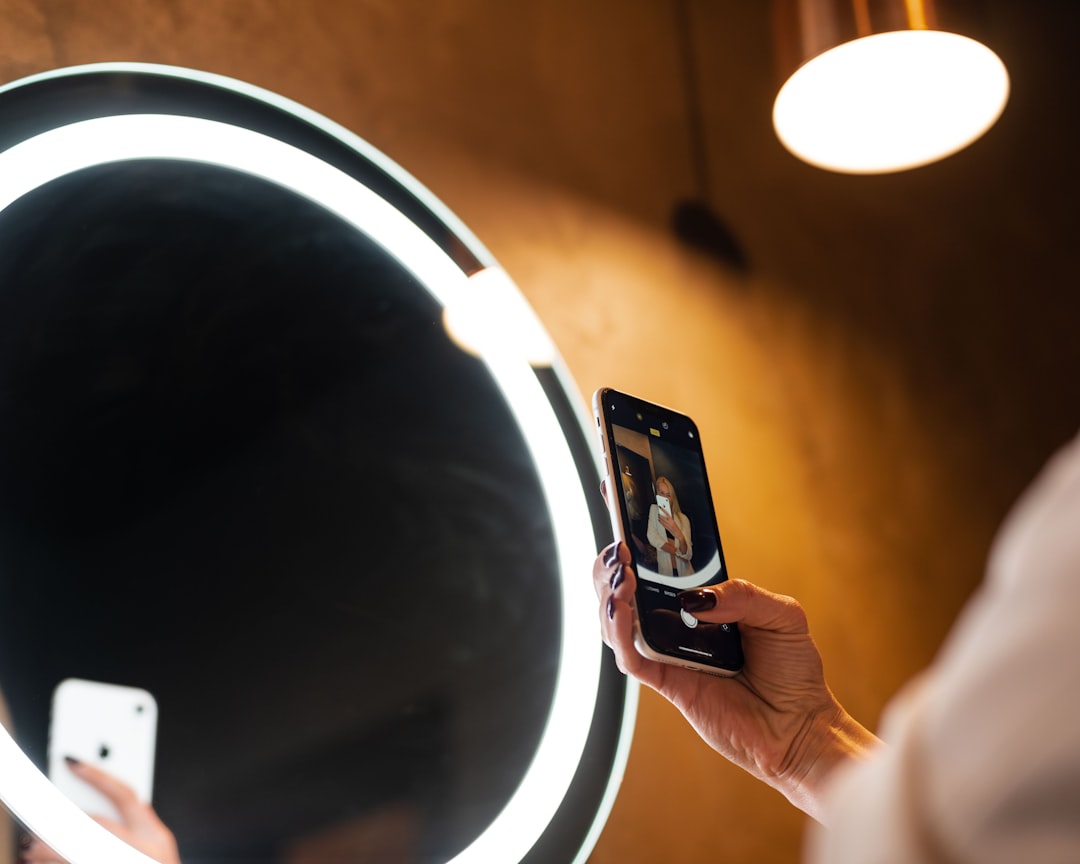 person holding iphone 6 taking photo of round mirror