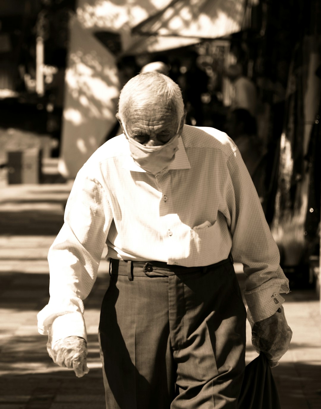 an old man walking down a sidewalk with a cane