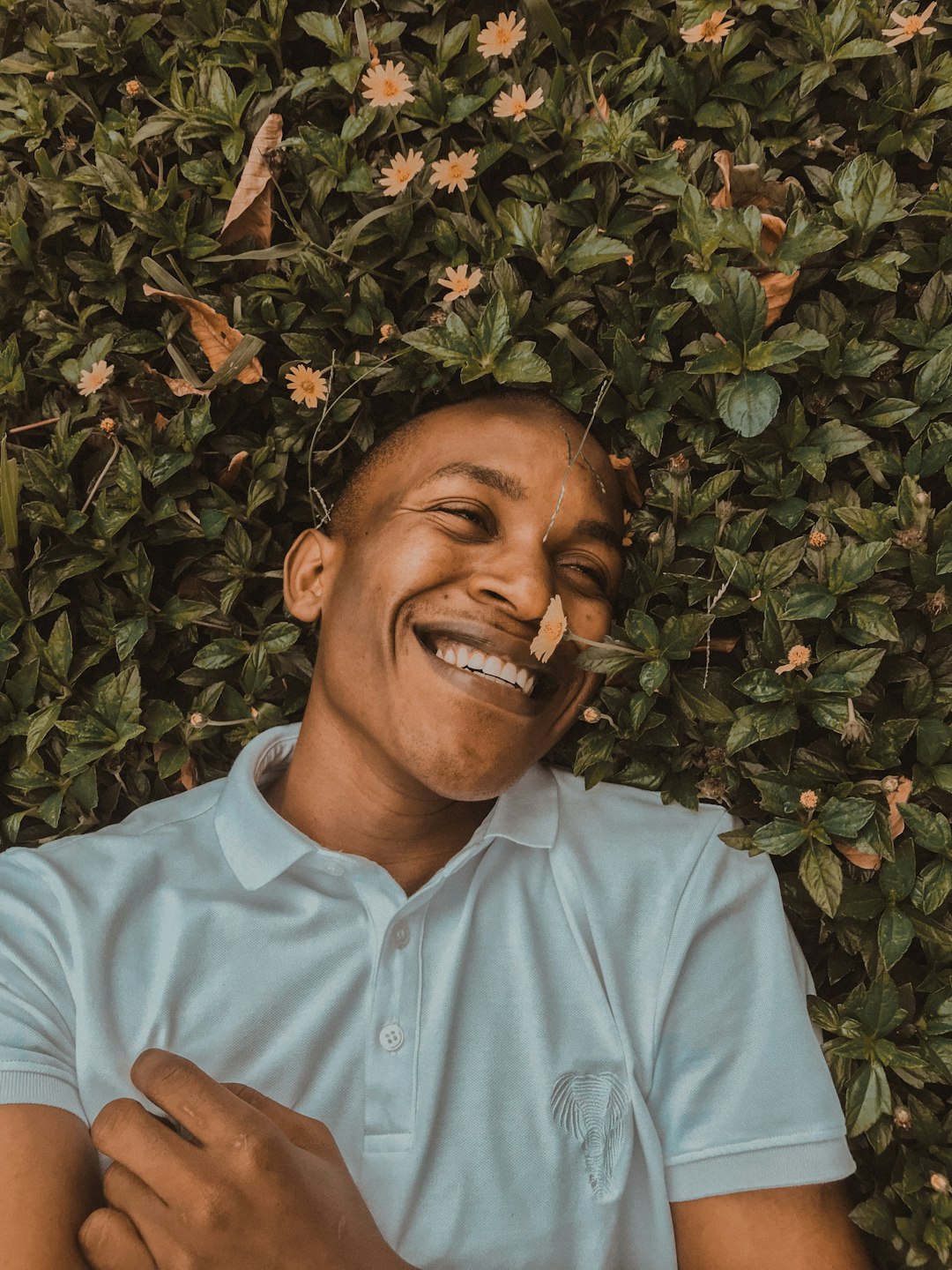 a man laying on top of a lush green field
