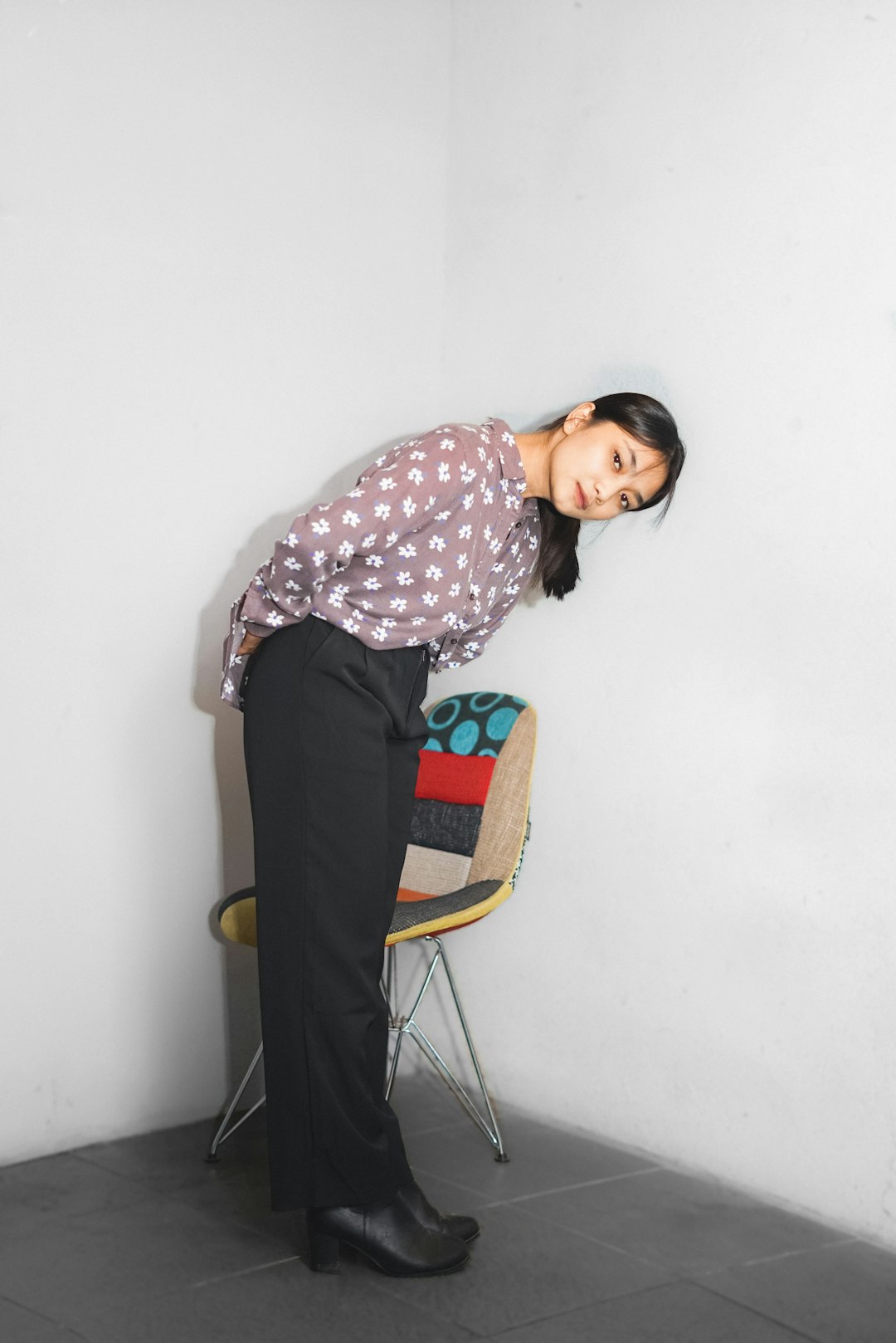 a woman standing next to a chair in a room