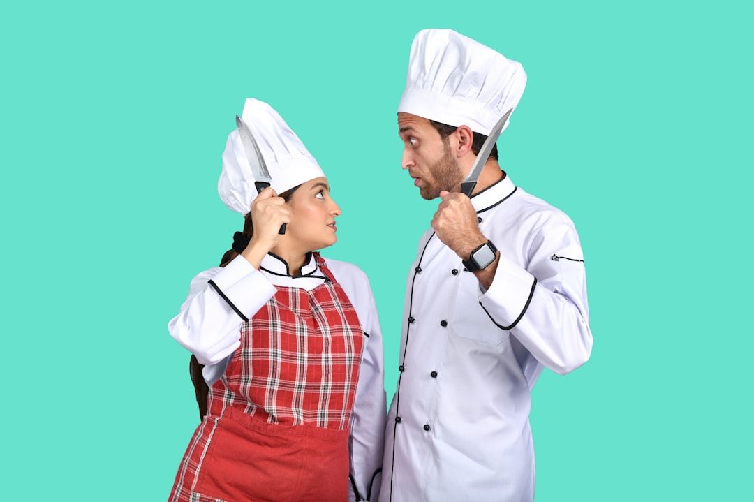 a man and a woman wearing white hats and looking at each other