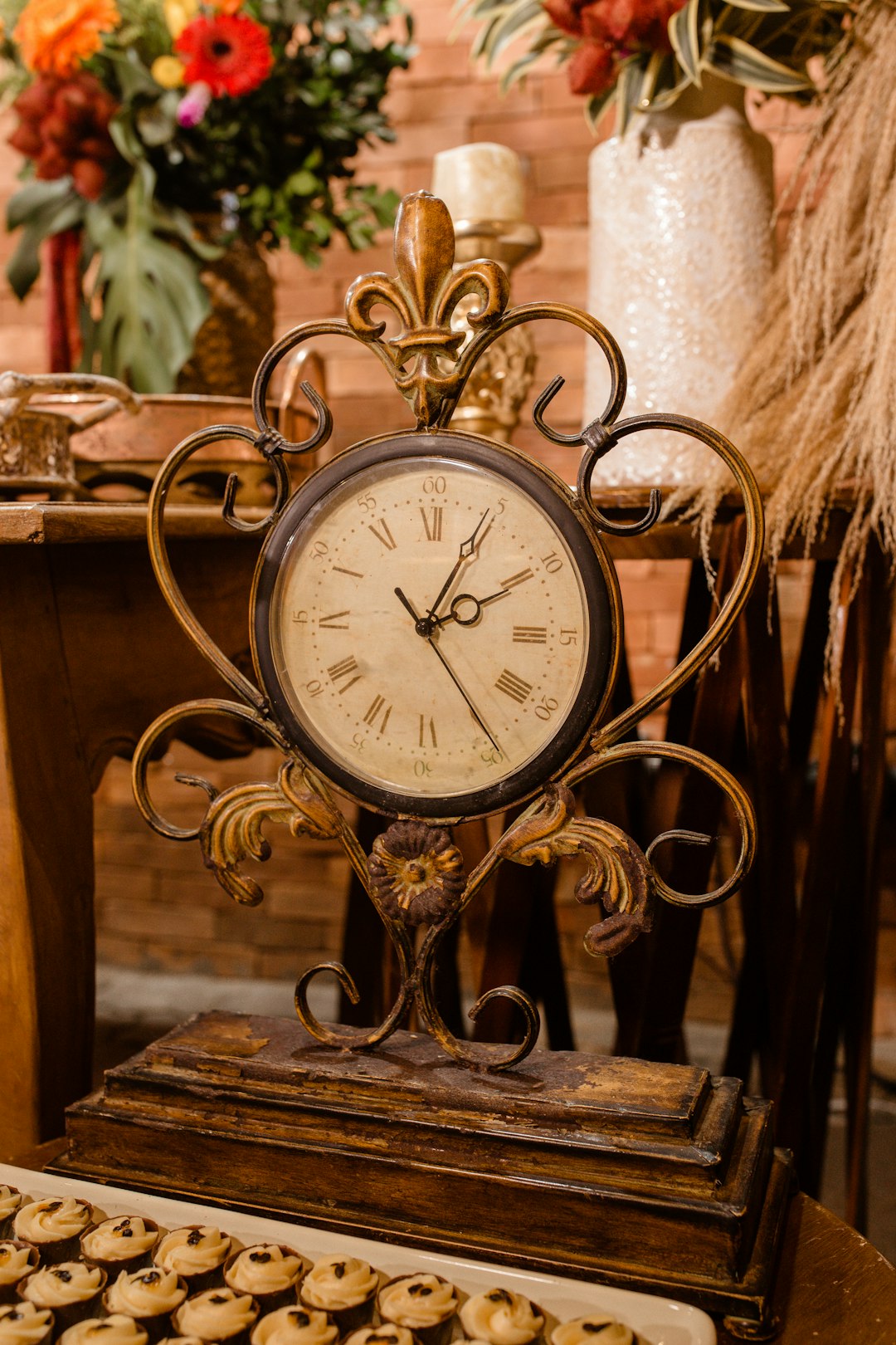A clock sitting on top of a table next to cookies
