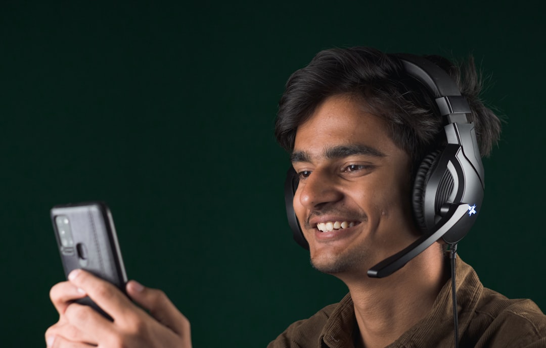 a man wearing headphones and holding a cell phone