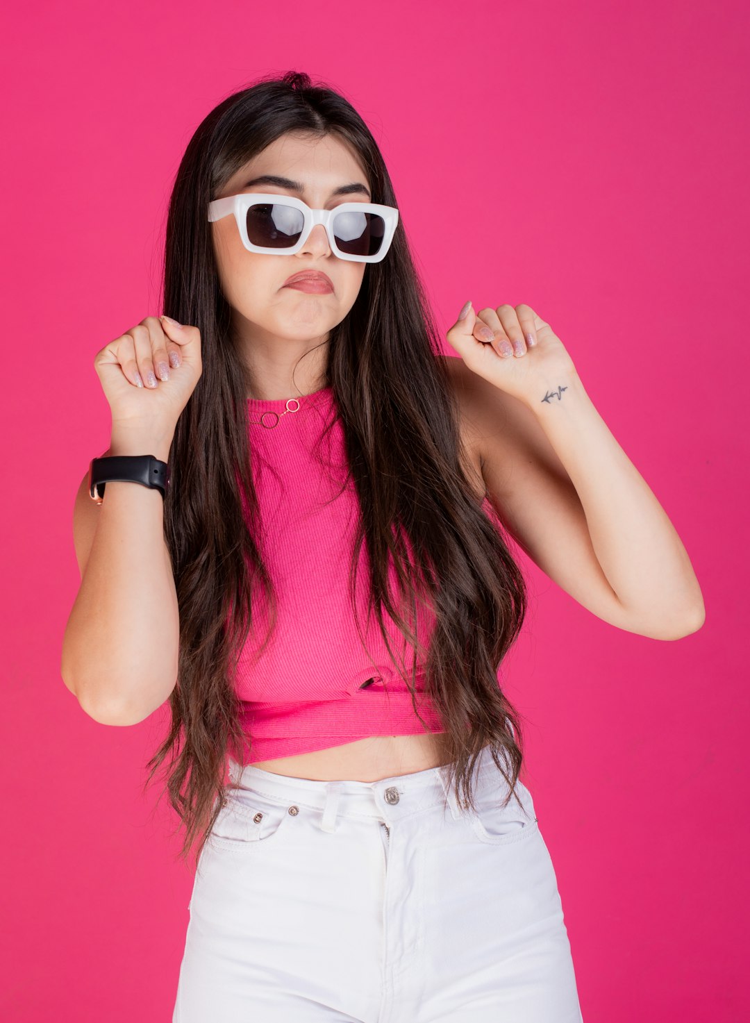 a woman wearing white sunglasses and a pink top