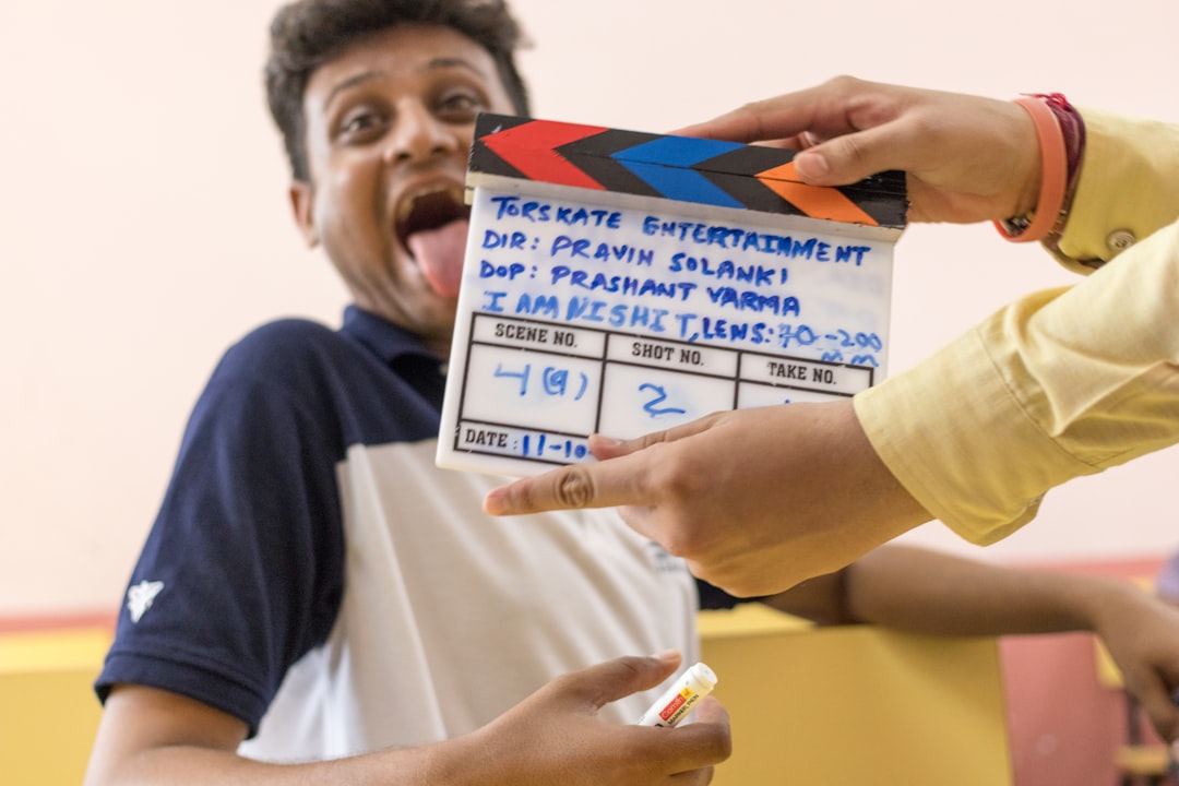 a man holding a movie clapper in front of a camera