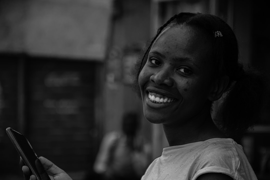 a woman smiles while holding a cell phone