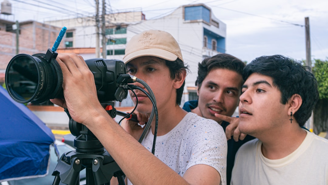 a group of young men standing around a camera