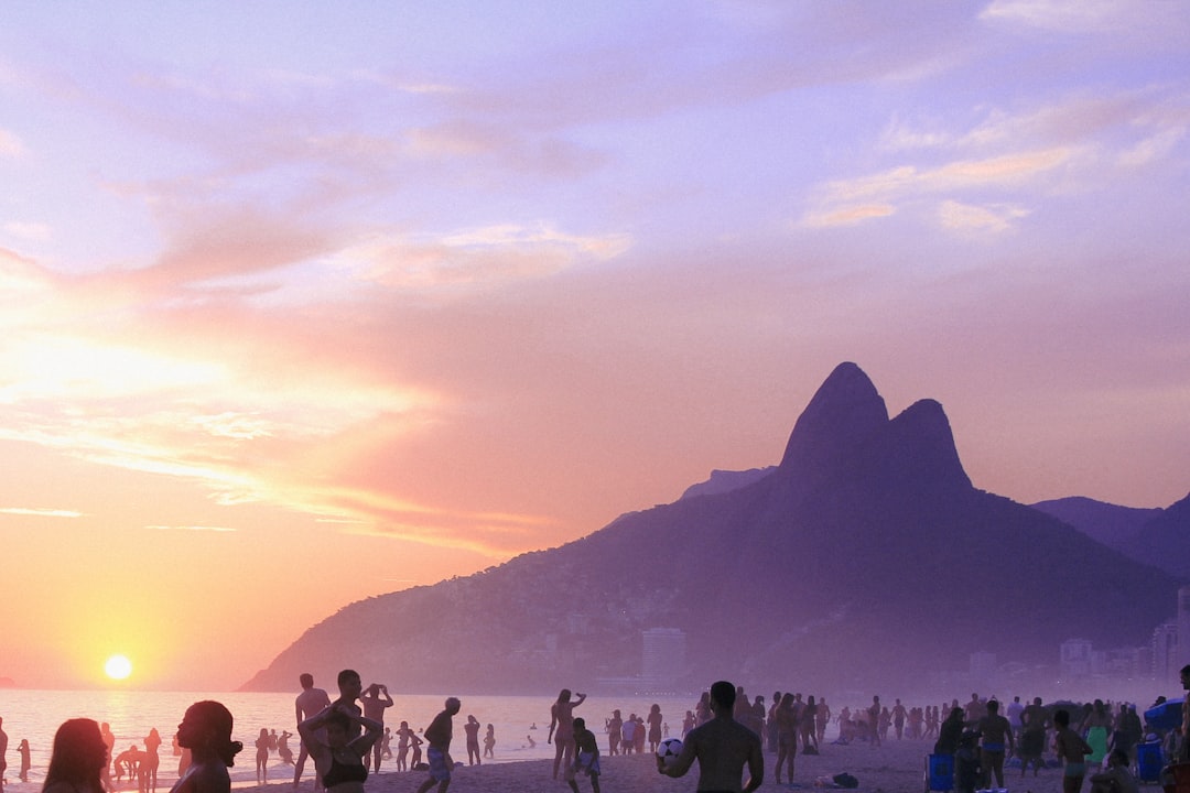 a group of people standing on top of a beach