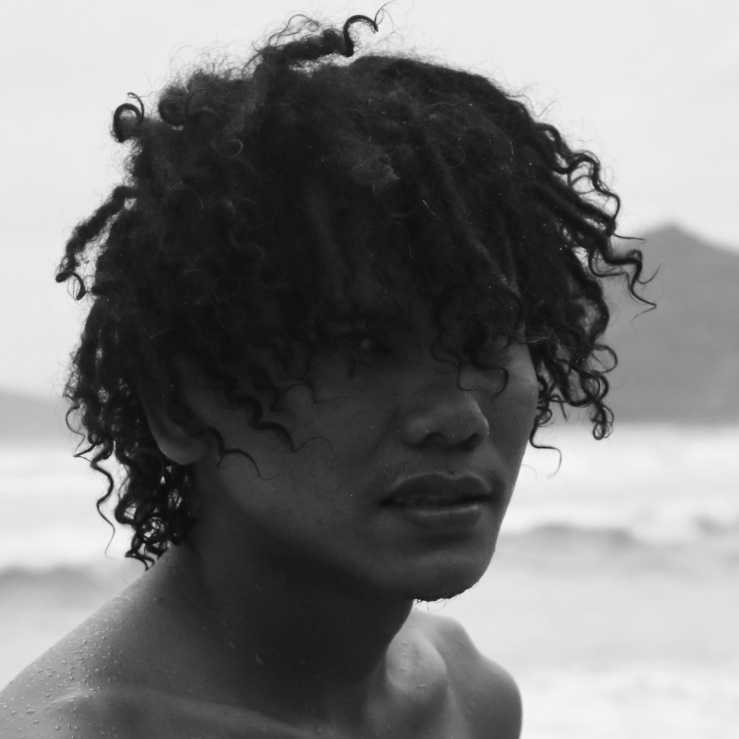 a black and white photo of a man with curly hair
