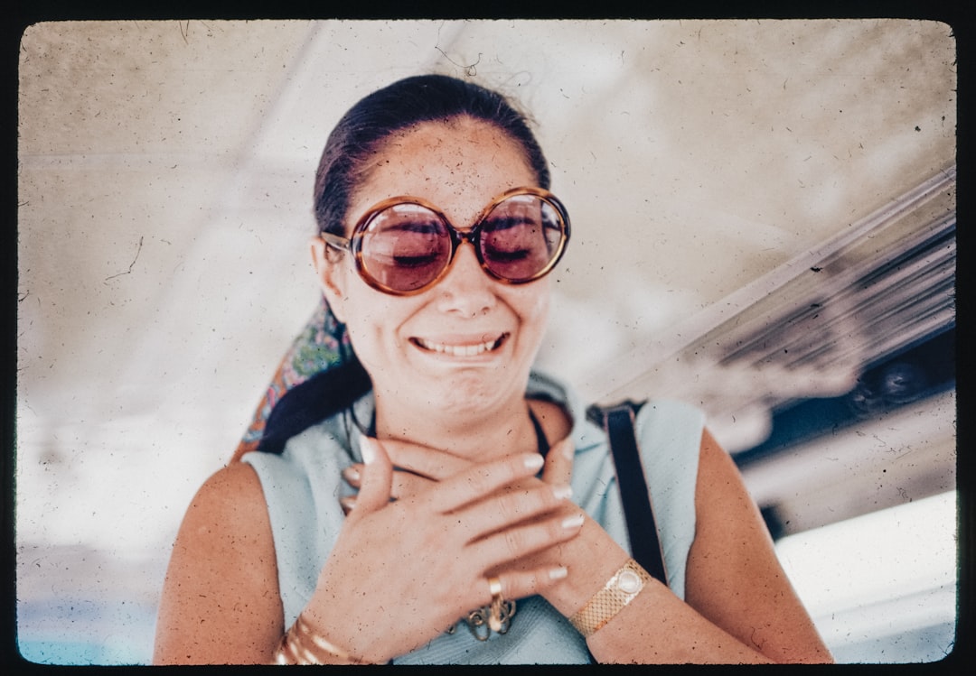A woman wearing sunglasses is smiling for the camera
