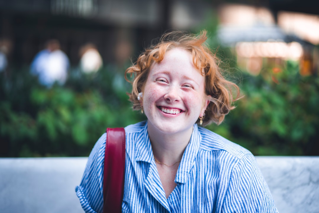 A woman sitting on a bench smiling at the camera