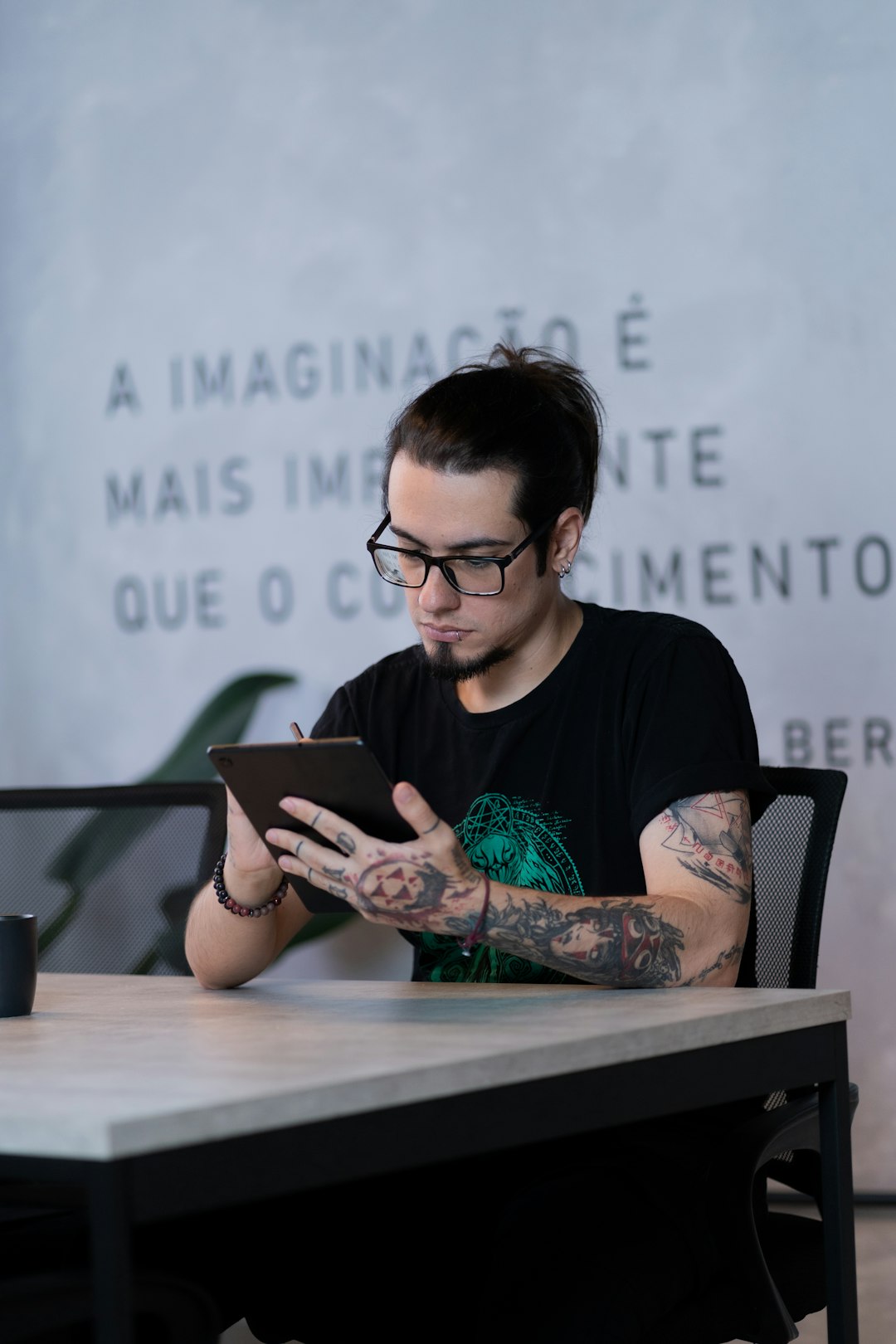 A man sitting at a table using a tablet