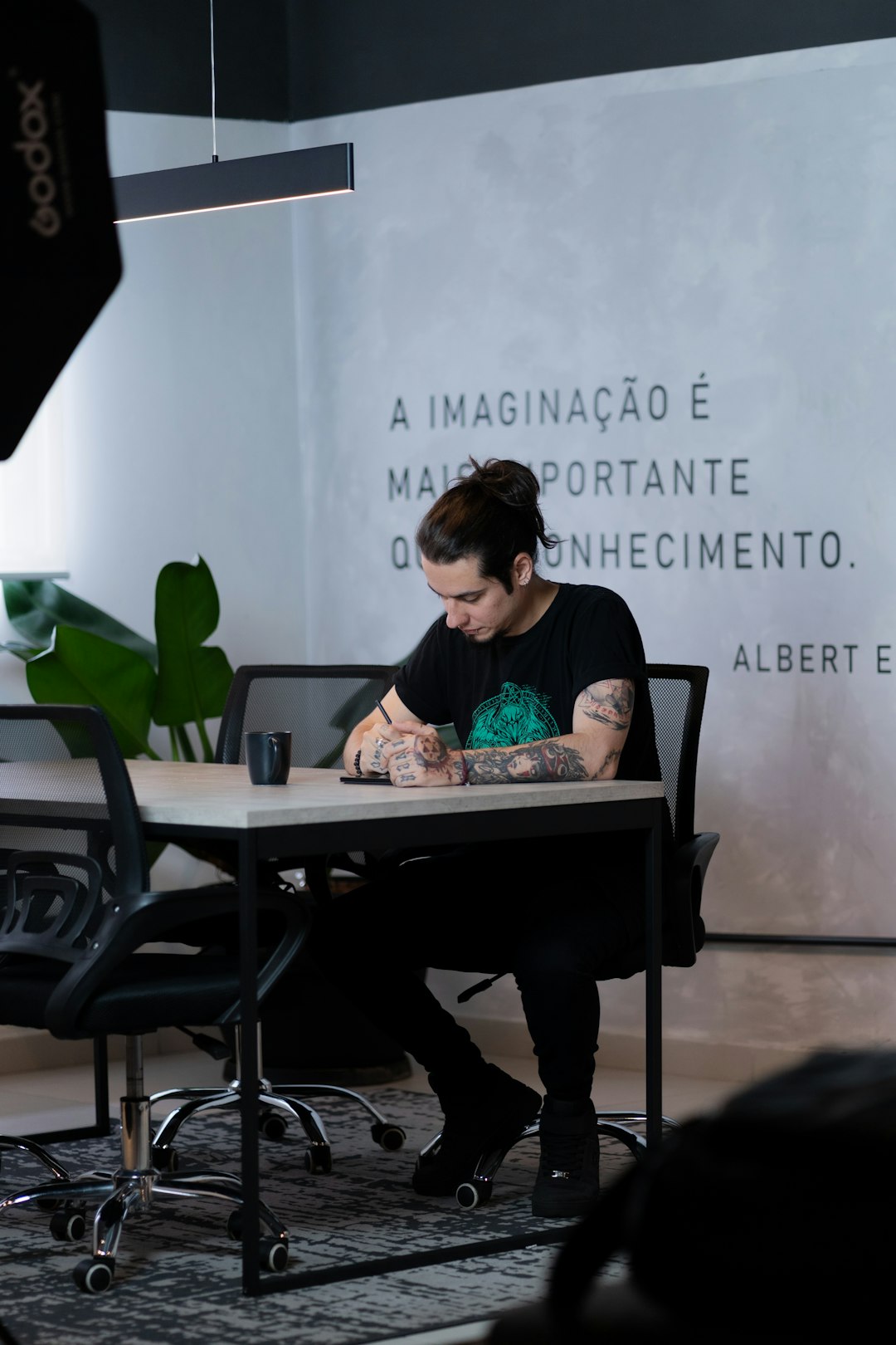 A man sitting at a table writing on a piece of paper