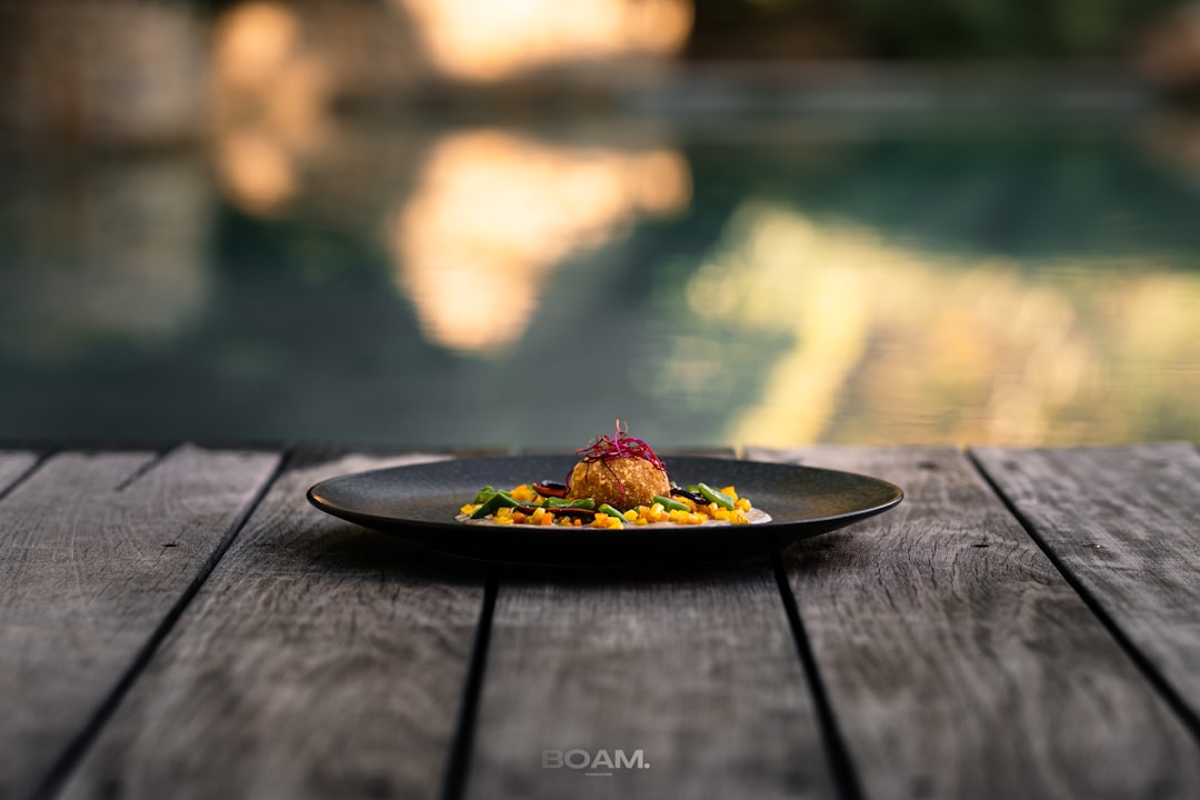 A plate of food sitting on a wooden table next to a pool