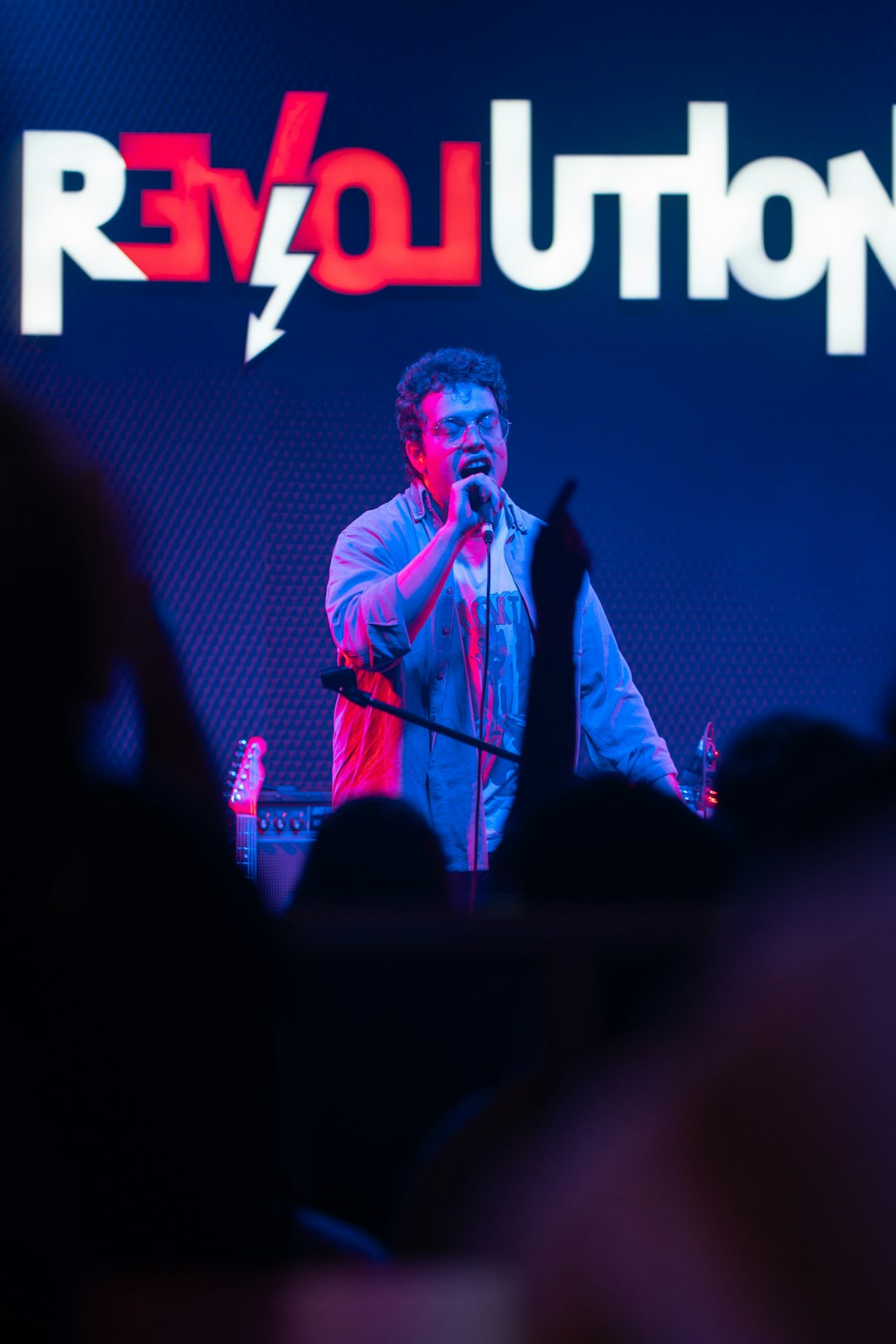 A singer performs on stage with bright lights.