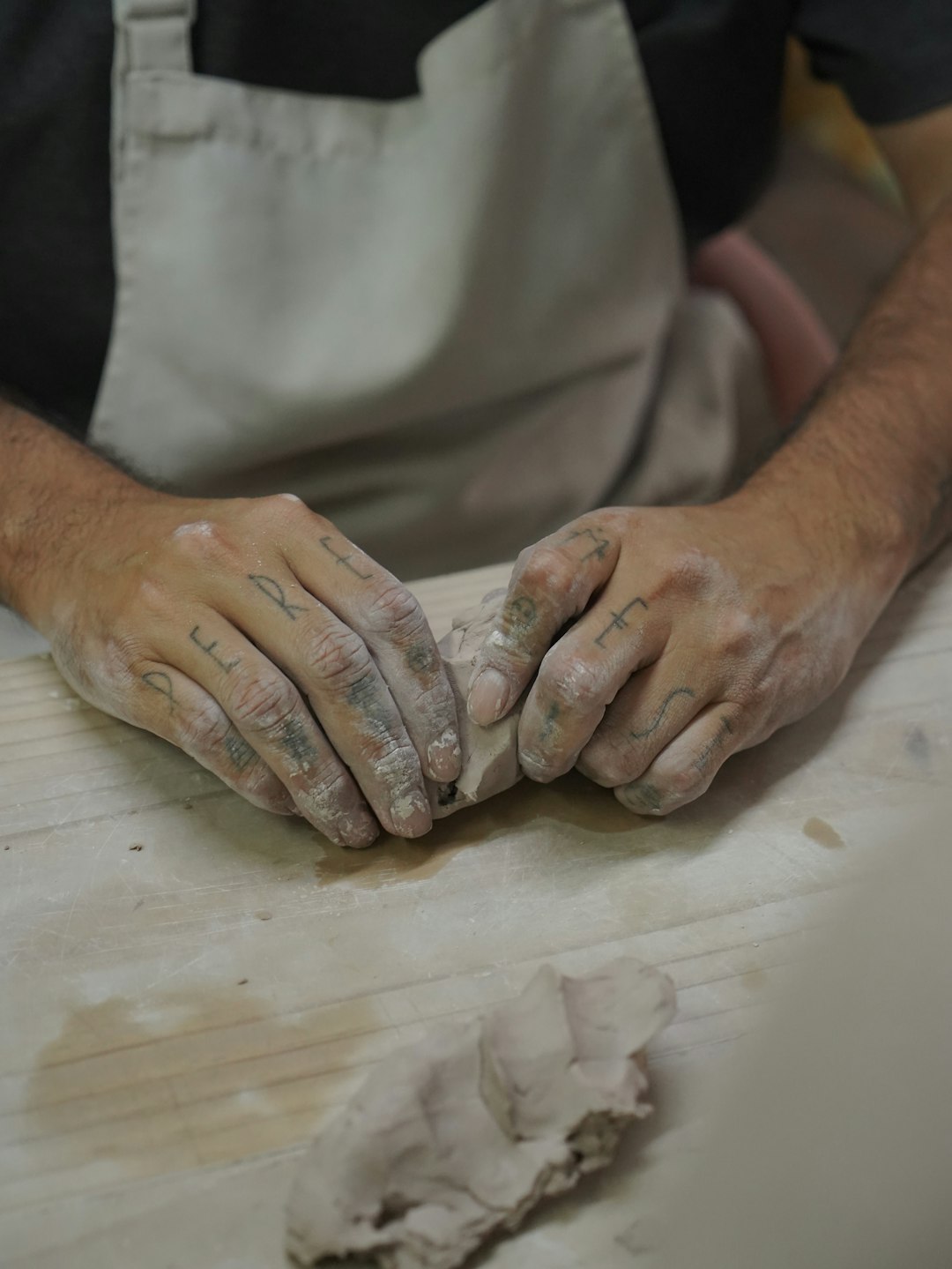 A person is shaping clay with their hands.