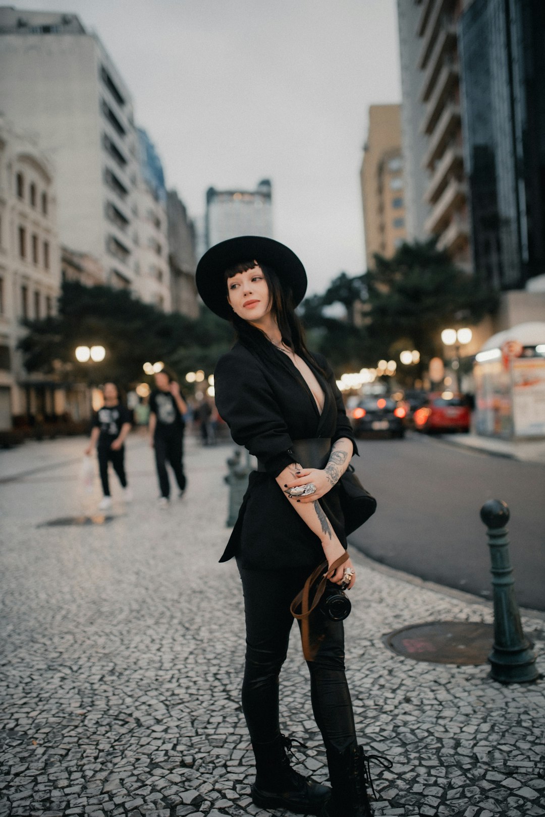A stylish woman poses on a city street.