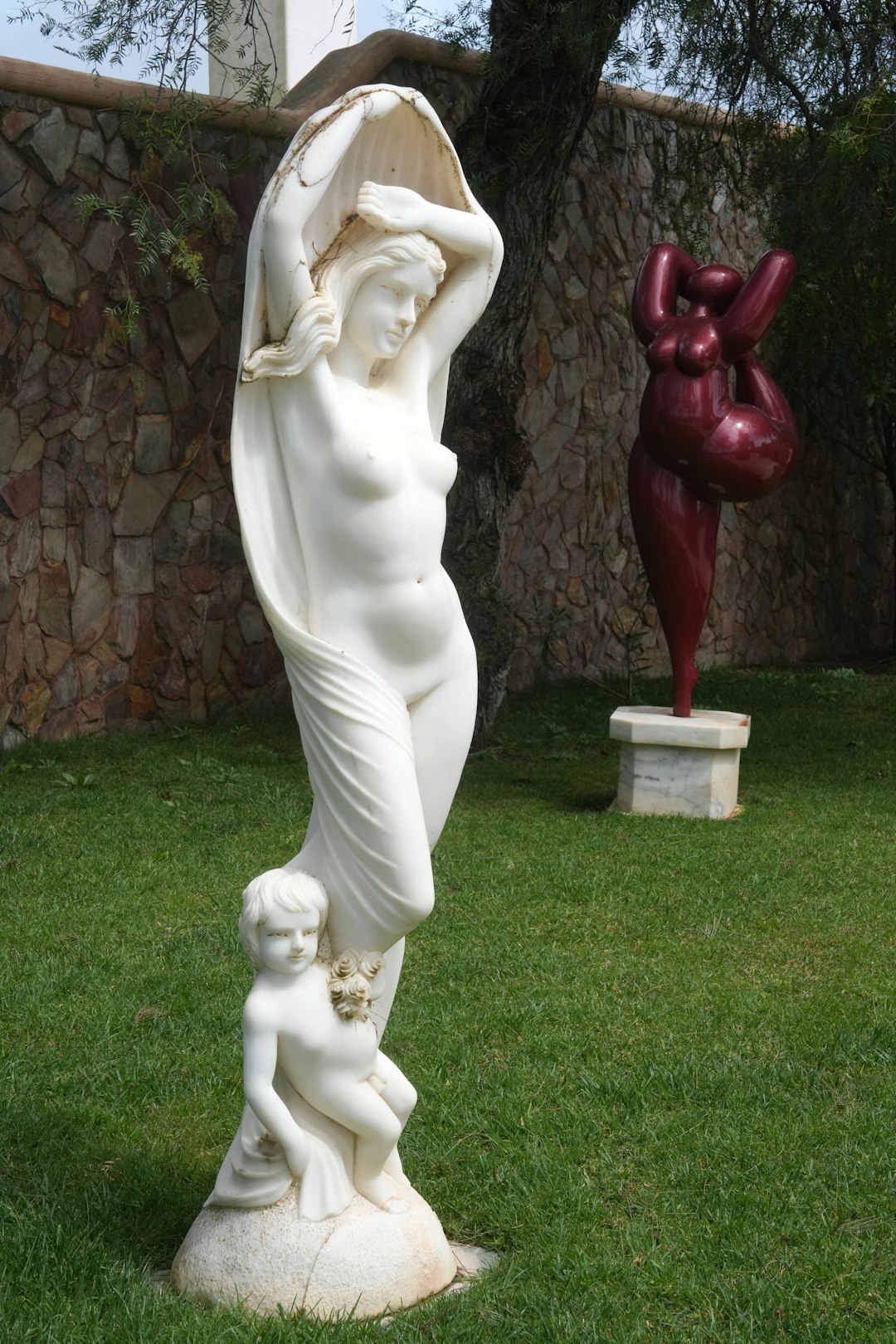 Statues of women and child in an outdoor setting.