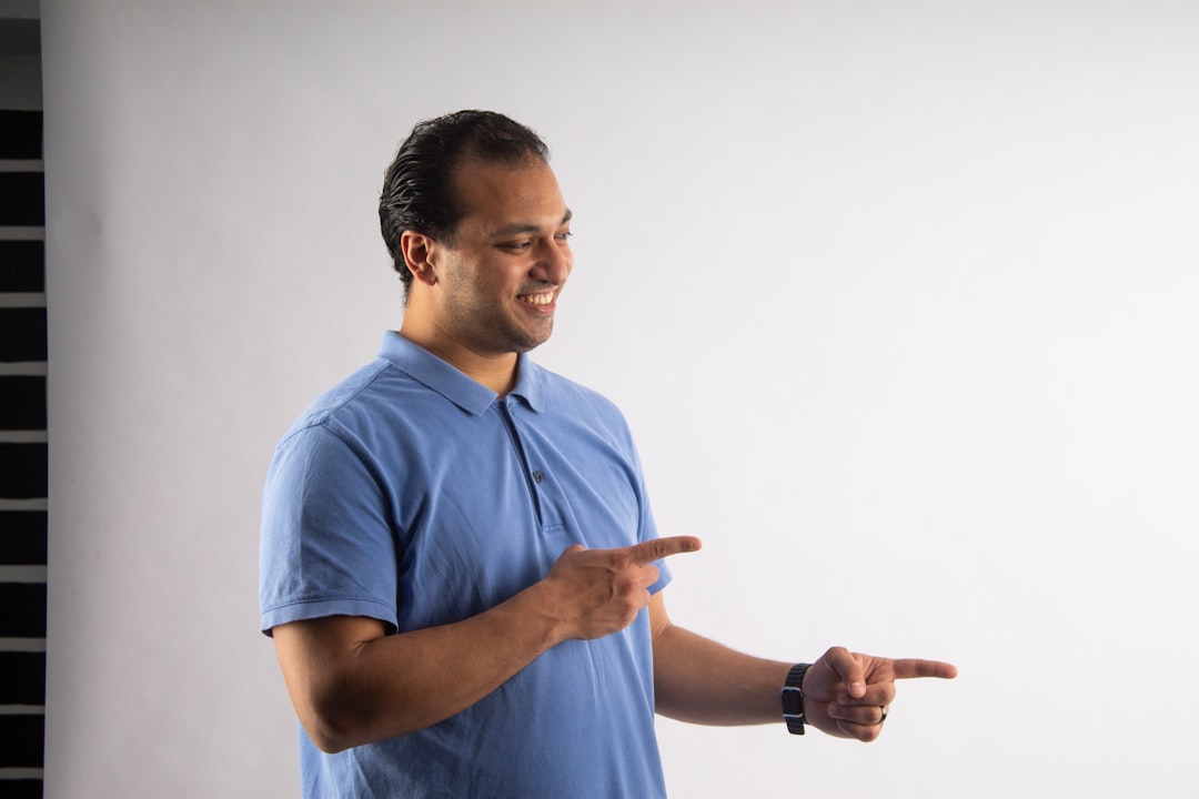 Man points to his right with a smile.