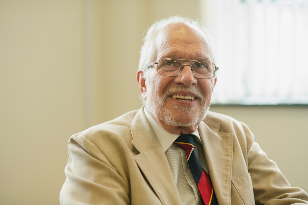 Smiling older man in a blazer.