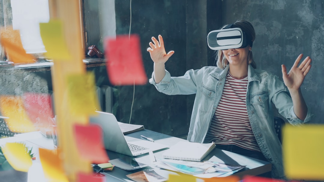 Woman happily experiencing virtual reality at her desk.