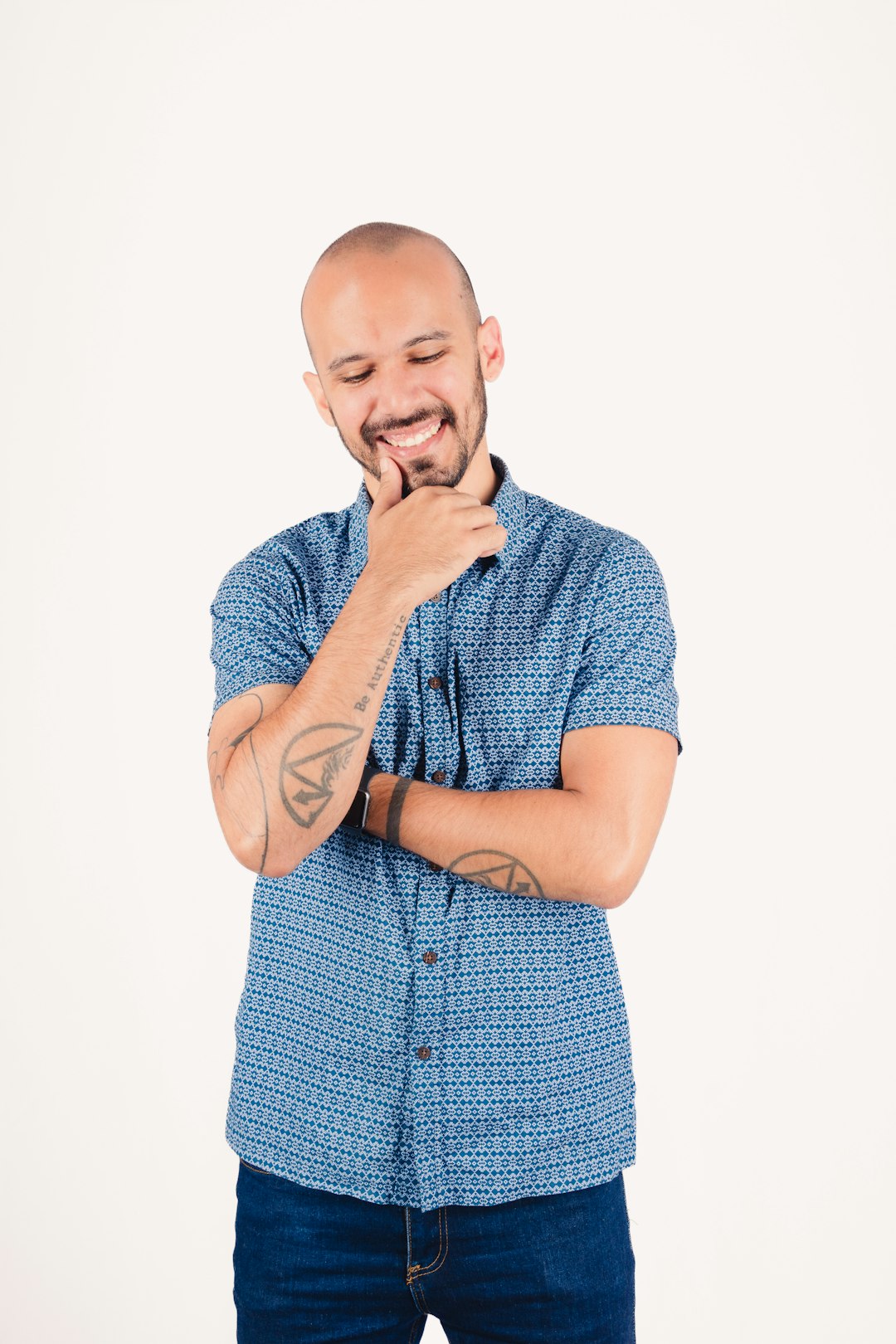 Man in blue shirt thinking with hand on chin