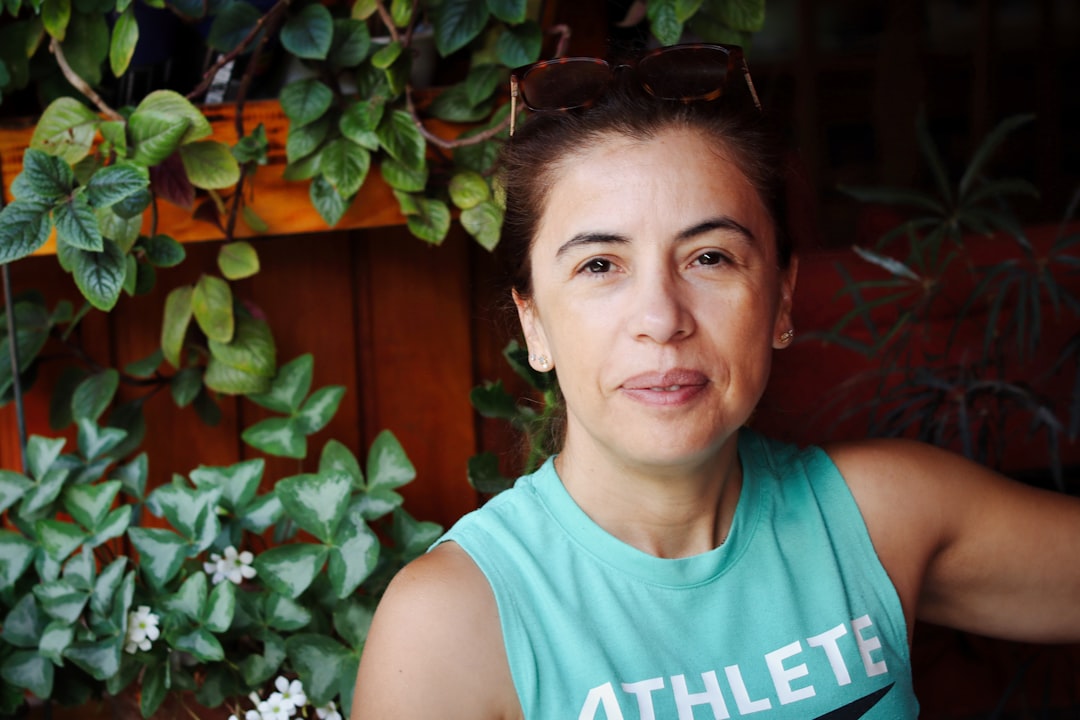 Woman in a teal tank top with plants