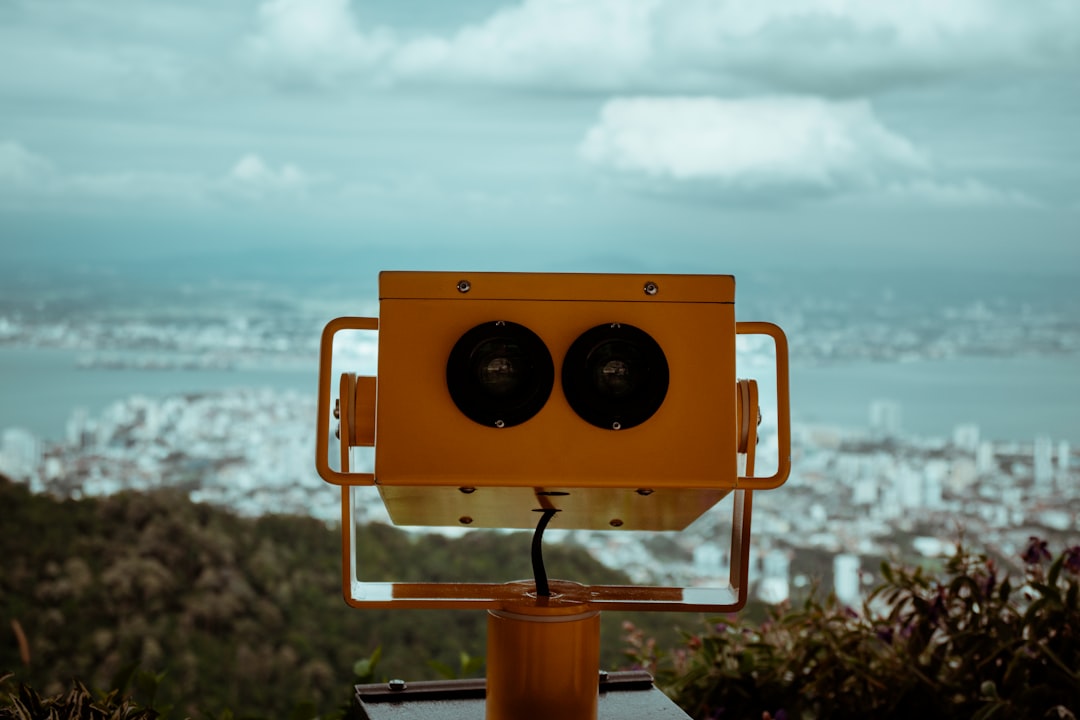 Orange binoculars overlooking a city and ocean