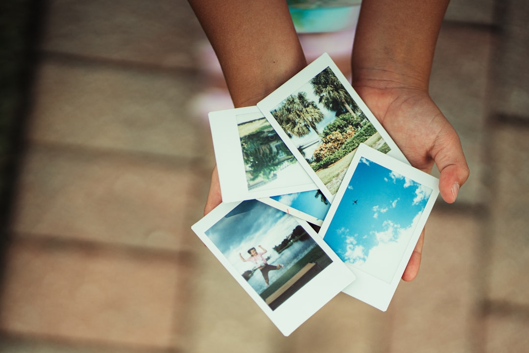 Hands holding a stack of instant photographs