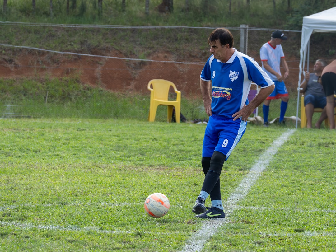 Soccer player in blue uniform with ball on field