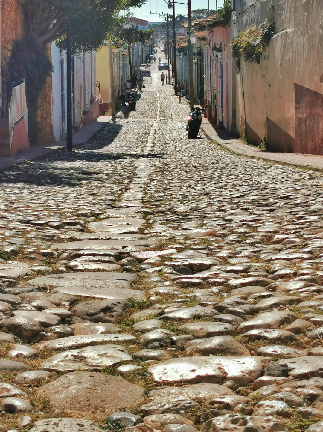 Cobblestone street lined with colorful buildings in a town.